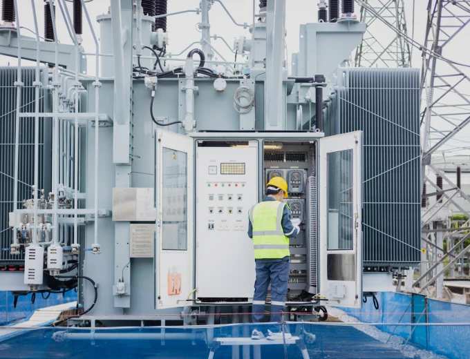 Worker in safety gear at control panel